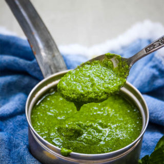 Fresh pesto sauce with a spoon to show smooth texture of the sauce