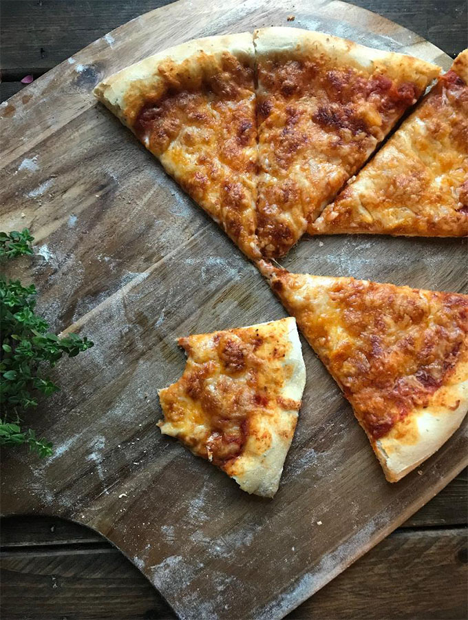 sliced cheese pizza on a cutting board