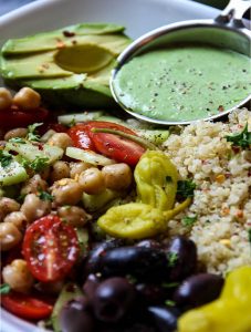 Mediterranean Quinoa Salad Bowl With Green Goddess Dressing in a little metal cup
