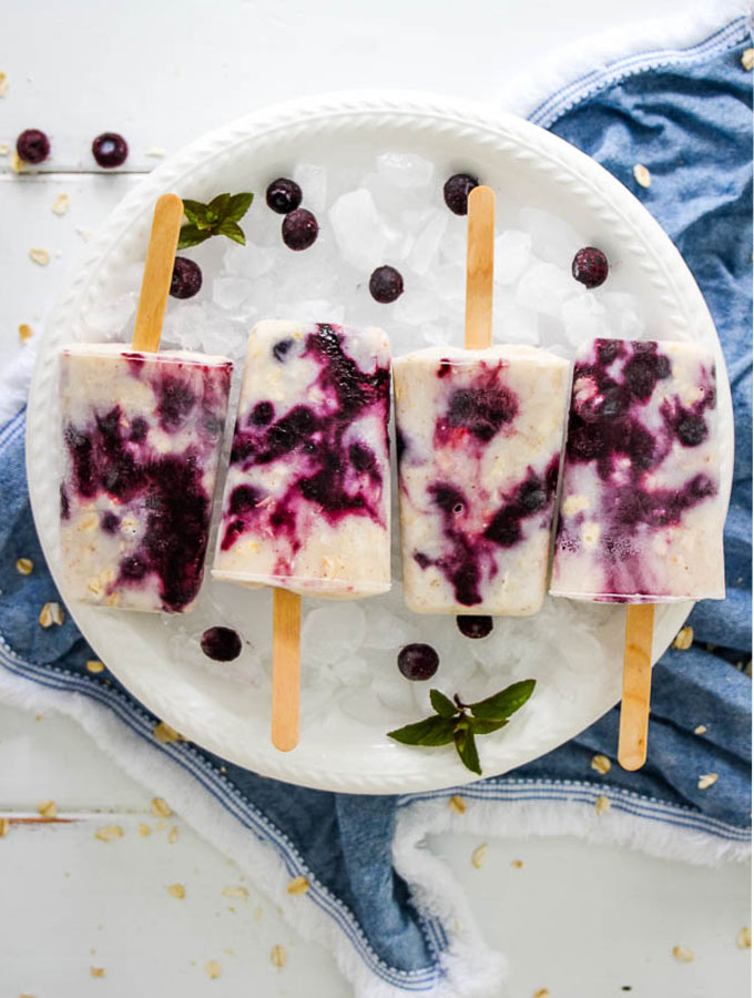 blueberry yogurt swirl Popsicle plated on a bowl of ice