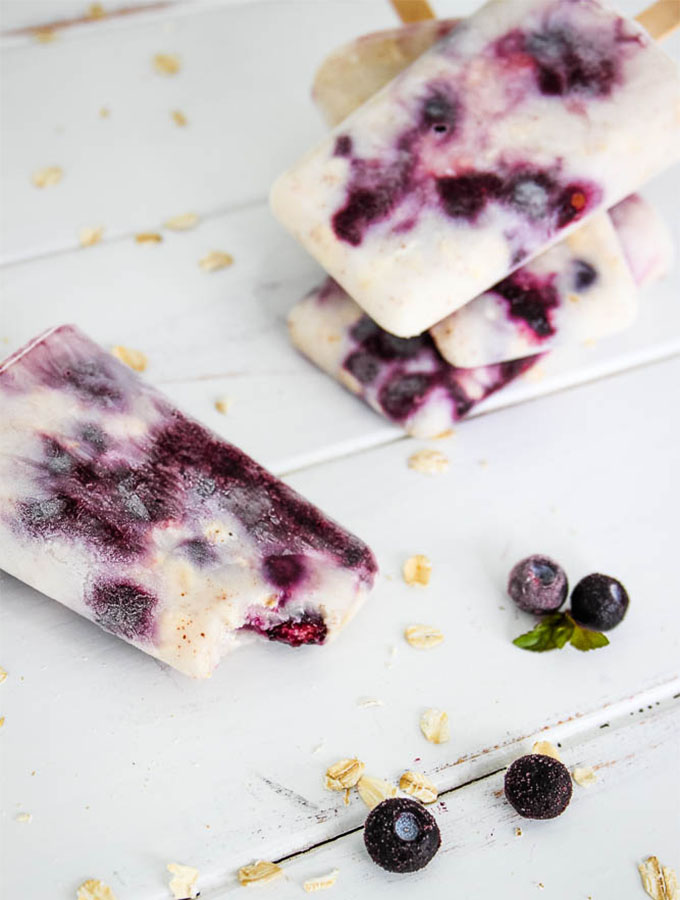 blueberry yogurt popsicles stacked with one biten.