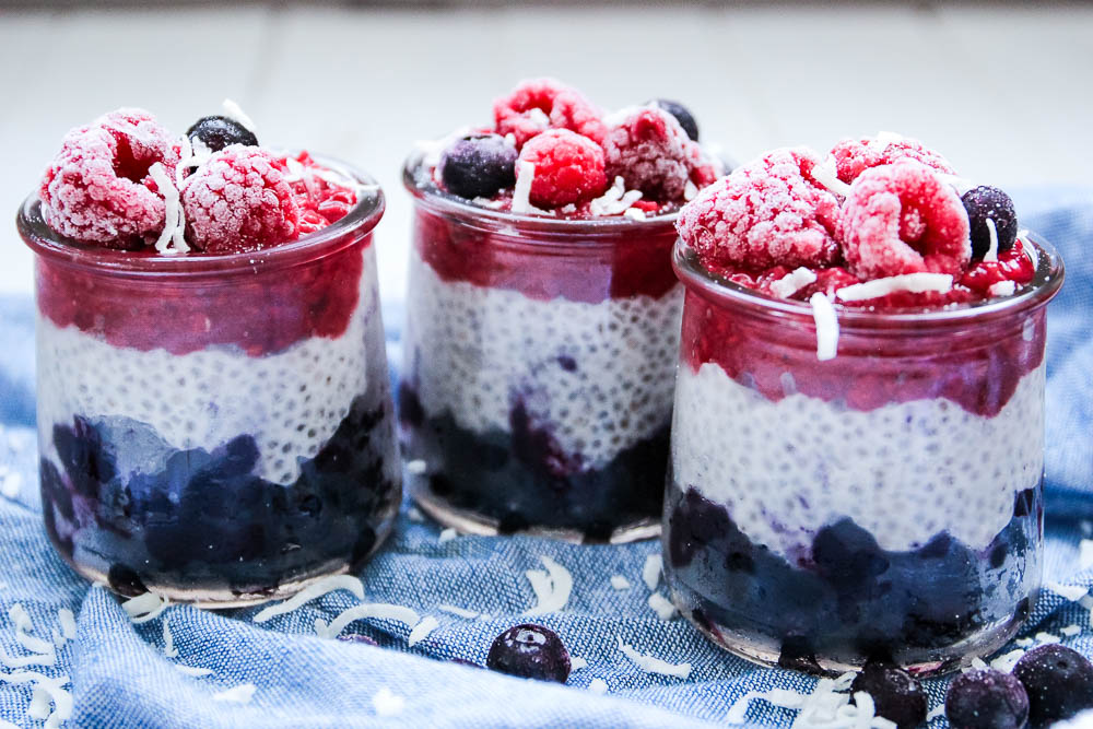 chia seed pudding topped with raspberries and blueberries in a glass jar