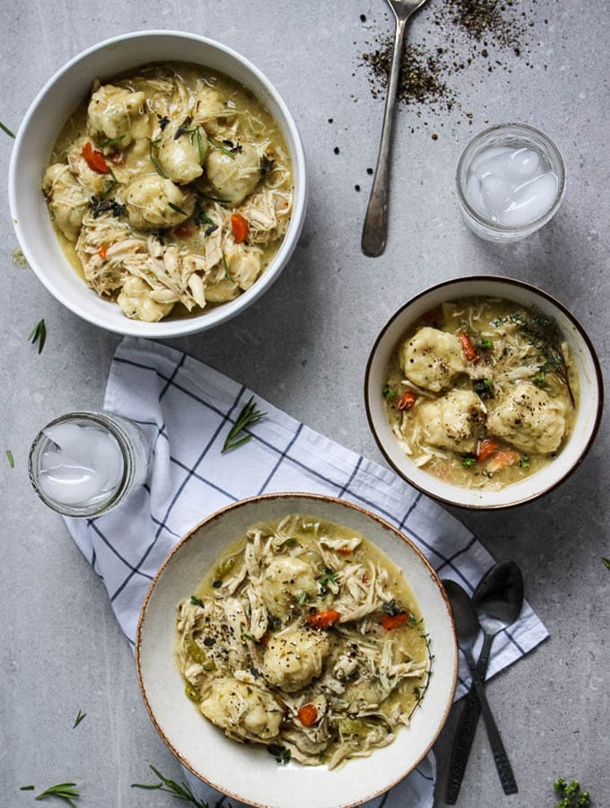 chicken and dumplings flat lay with three bowls filled with soup