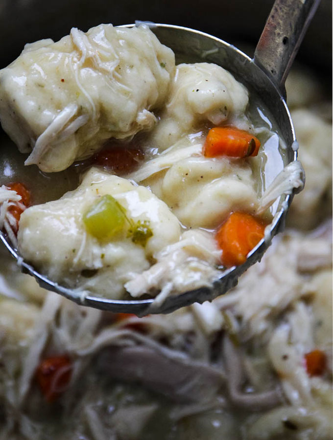 chicken in dumplings close up shot in a ladle to show texture and creaminess.