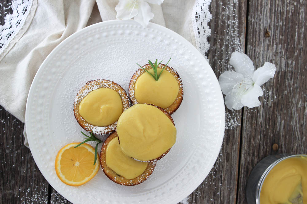 Mini Dutch Babies with lemon curd is plated on a white plate.