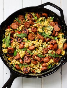 Breakfast Scramble with chicken sausage, spinach, arugula, bell peppers and scrambled eggs is easily cooked in a cast iron pan.