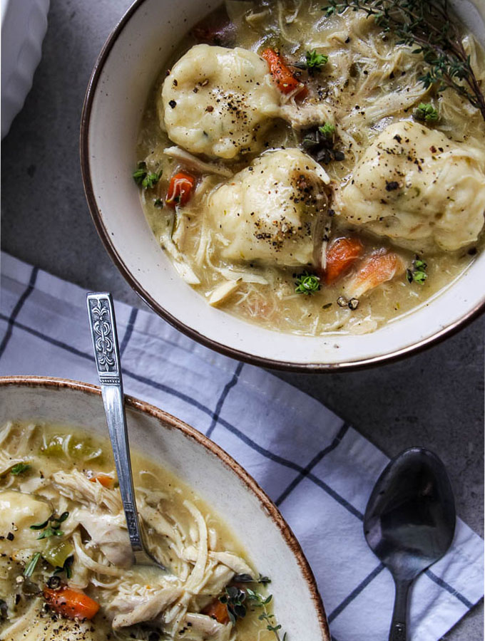 bowls of chicken and dumplings with spoons