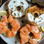 Lox of bagels is made with cream cheese, bagels, and smoked salomon with bits of fresh dill, capers, and a cucumber sauce.