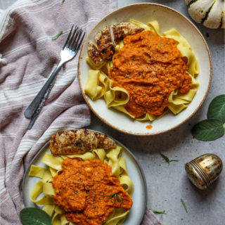 Pumpkin pasta sauce with Italian chicken lated on pottery plates with fresh sage