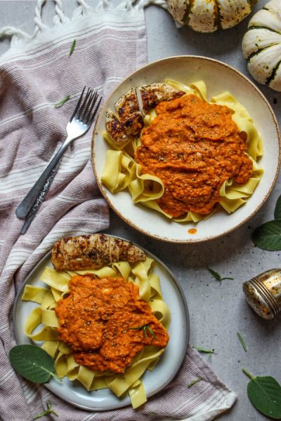 Pumpkin pasta sauce with Italian chicken lated on pottery plates with fresh sage