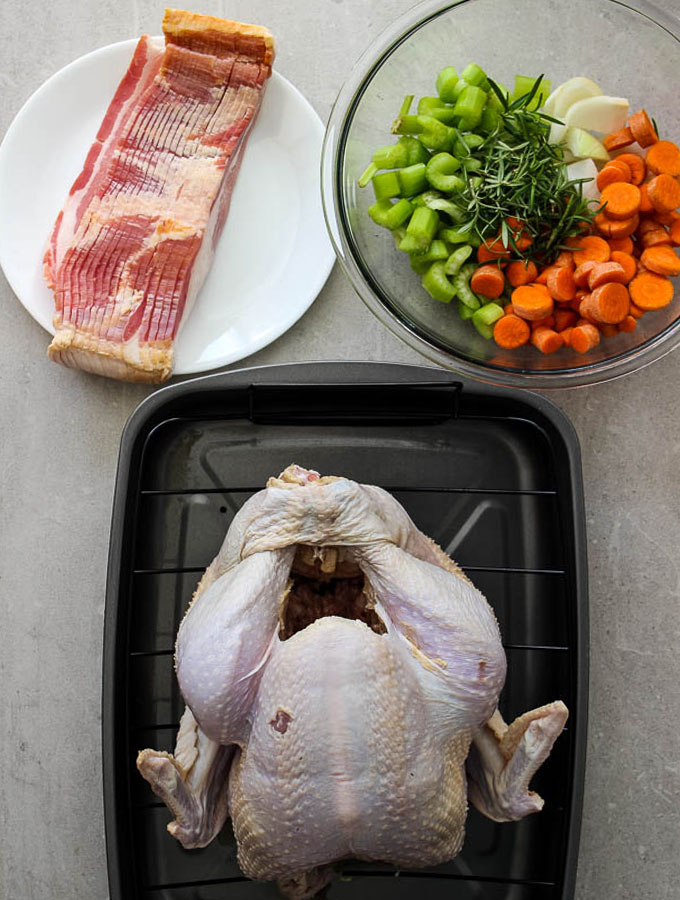 Bacon wrapped turkey ingredients are minimal, only using a whole tukey, bacon, carrots, celery, onion, and rosemary.