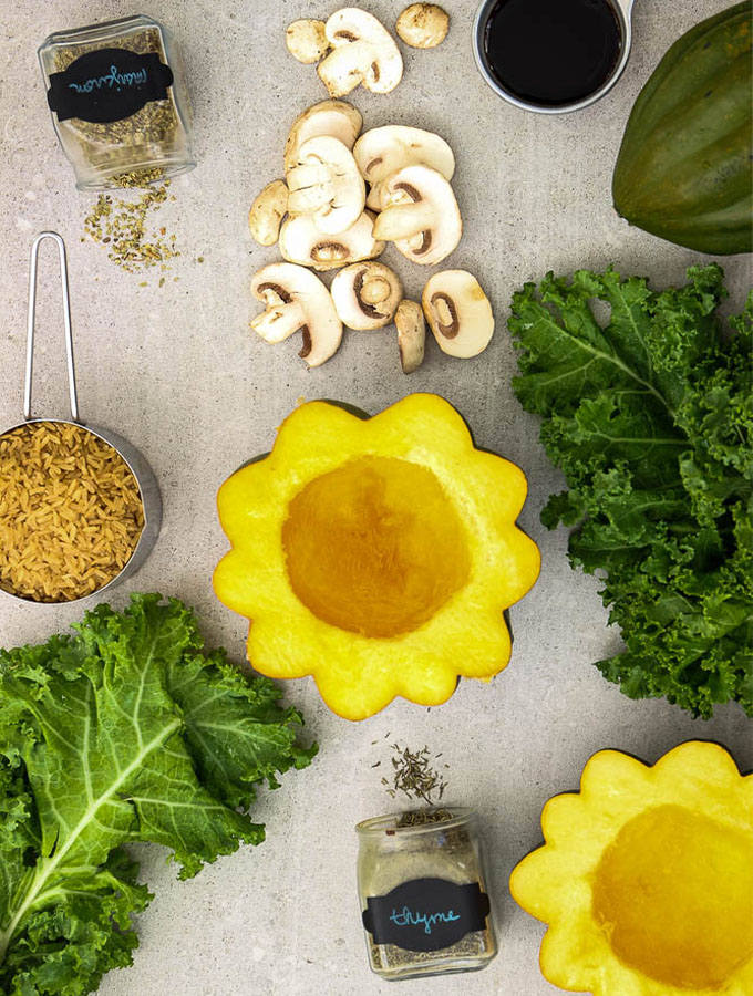 Stuffed acorn squash ingredients are displayed and include acorn squash, rice, mushrooms, kale, thyme, marjoram, and soy sauce.