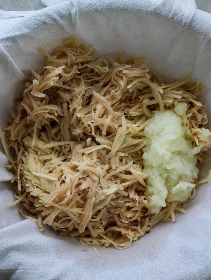 Potato latke ingredients are combined in a cheese cloth to strain the excess water before frying.