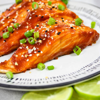 Sriracha Honey Baked Salmon is plated and topped with chives.