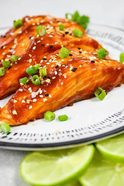 Sriracha Honey Baked Salmon is plated and topped with chives.