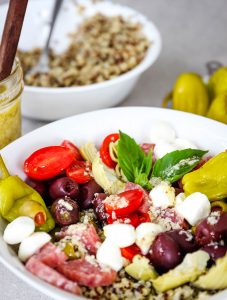 Antipasto Quinoa Salad is plated and topped with white wine vinaigrette.