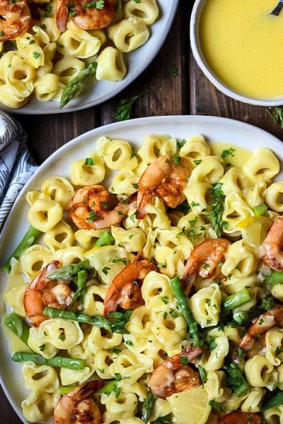 Shrimp and Tortellini with Beurre Blanc is plated and served with an extra dish holding the beurre blanc sauce.