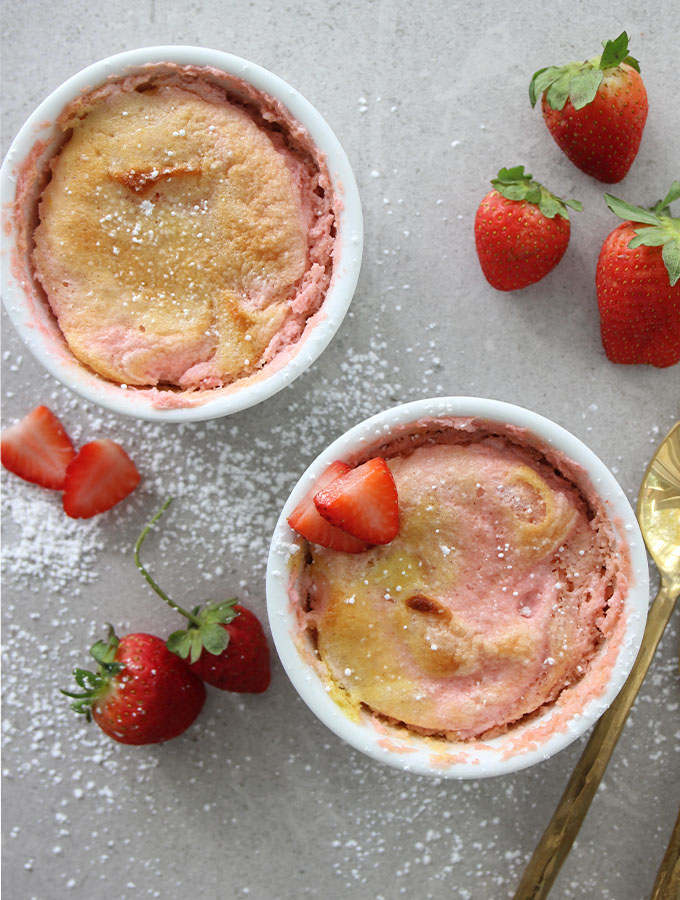 Strawberry Soufflé is dusted with powdered sugar and sliced strawberries.