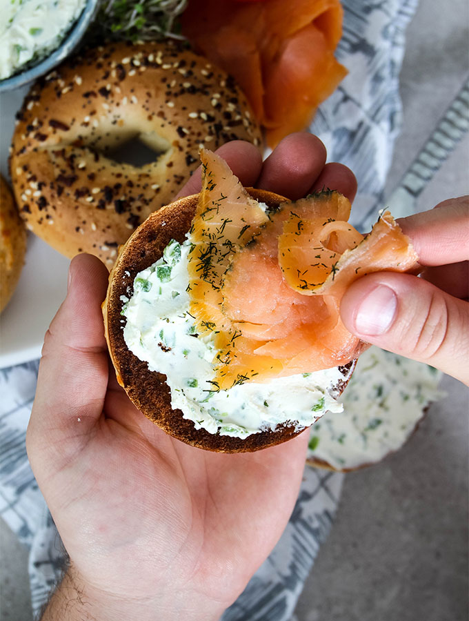 Lox is placed on a cream cheese covered bagel.