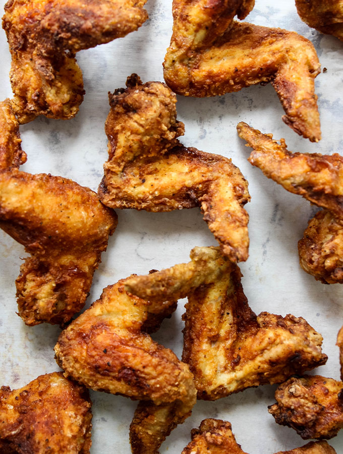 Lemon pepper chicken wings are plated after they are fried.