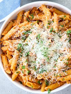 Penne alla vodka is topped with freshly grated parmesan cheese.
