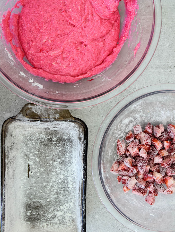 Strawberry bread batter is mixed and the strawberries are tossed in flour.