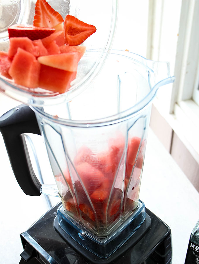 Fresh watermelon and strawberries are added to a high powered blender to make the frozen margaritas.