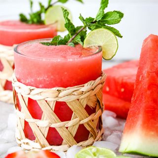 Frozen Strawberry Watermelon Margaritas are poured into small decorative glasses and plated with more fresh watermelon.