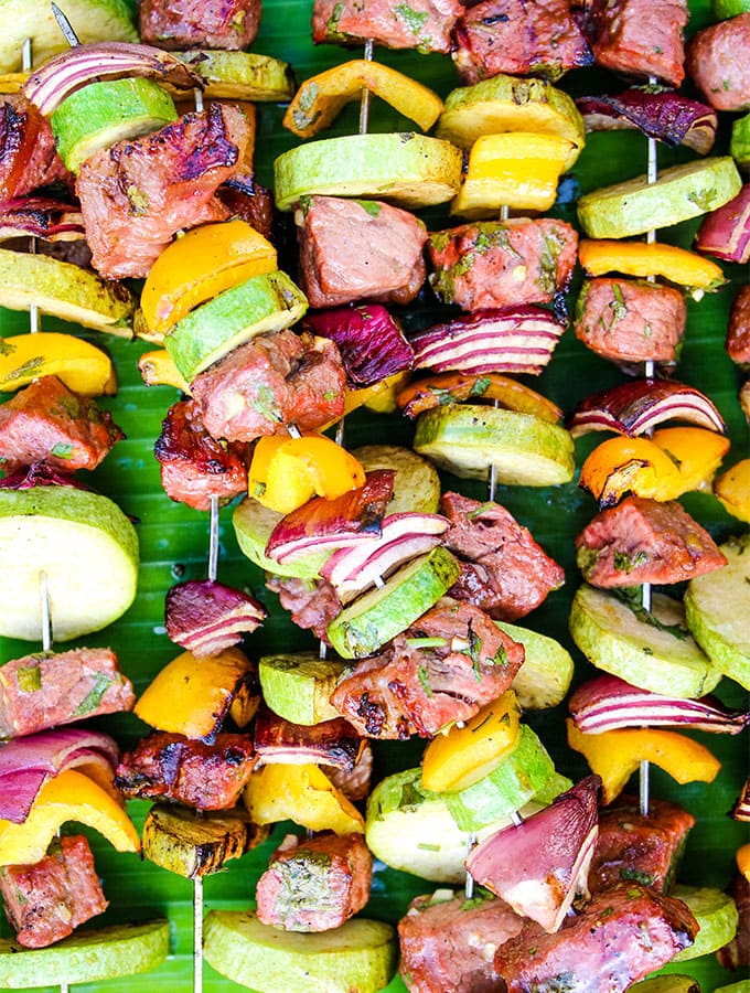 Grilled Carne Asada Kabobs are grilled and stacked on top of a banana leaf.