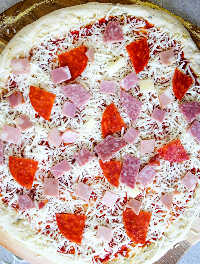 Italian sub pizza is topped with pepperoni, mortadela, capicola, and salami.