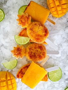 Mango and Tajin paletas are plated on top of ice and stacked.