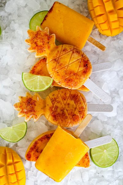 Mango and Tajin paletas are plated on top of ice and stacked.