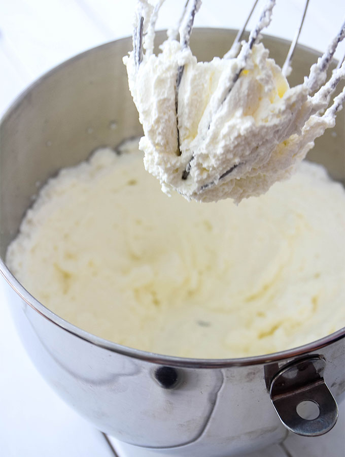 Heavy cream is whipped in a stand mixer until stiff peaks form.