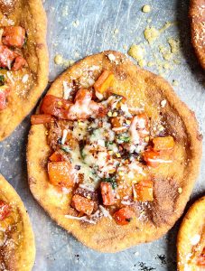Deep Fried Neapolitan Pizza is baked on a baking sheet, then topped with red pepper flakes.
