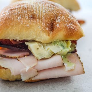 Turkey and Bacon Sandwich with Basil Aioli is plated for a close up shot.