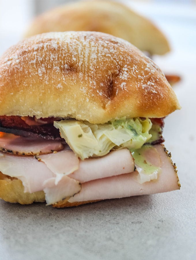 Turkey and Bacon Sandwich with Basil Aioli is plated for a close up shot.