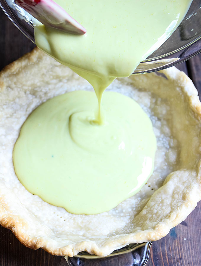 The key lime filling is poured into the baked pie crust.