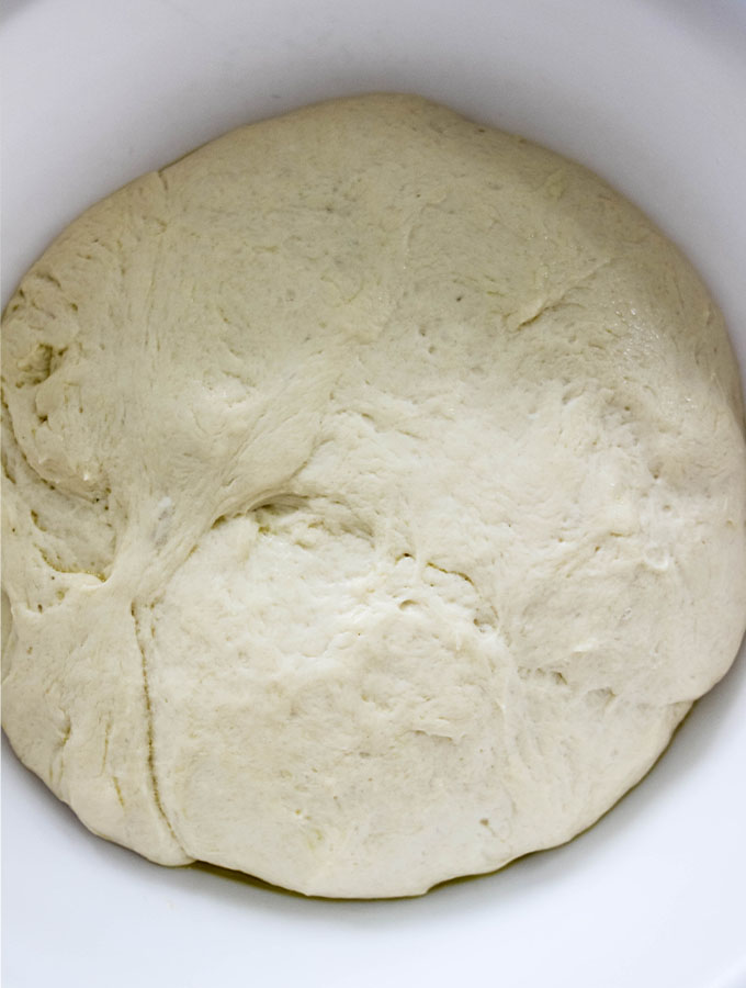 Easy Olive and Herb Focaccia dough is rising in a bowl.