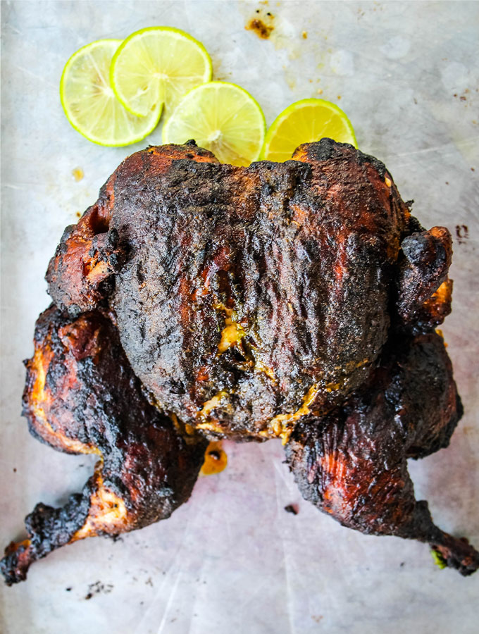 Peruvian Spatchcock Chicken with Aji Verde Sauce is placed on a baking sheet after it's cooked.