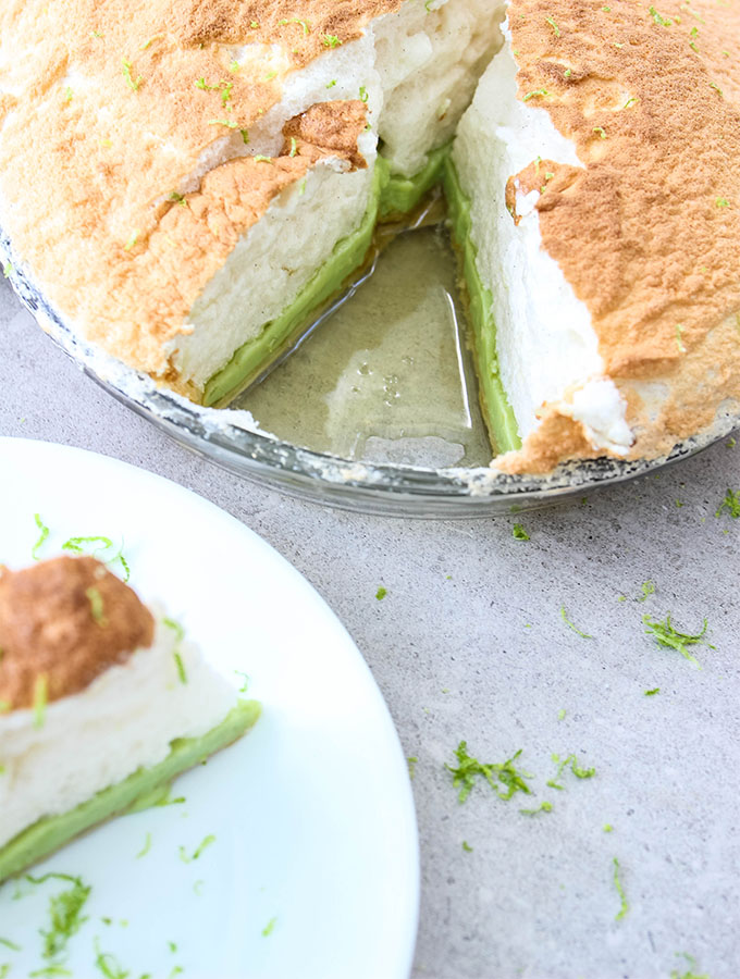 A slice of Authentic Key Lime Pie with Meringue is plated on a white plate.