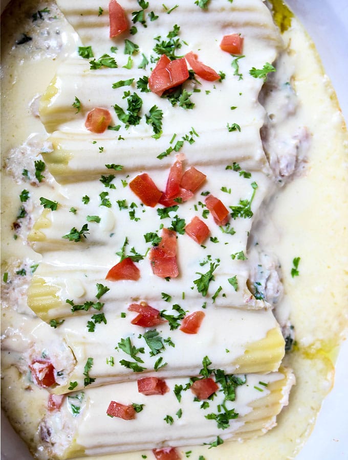 Crab Stuffed Manicotti with Alfredo Sauce is baked, then topped with tomatoes and parsley
