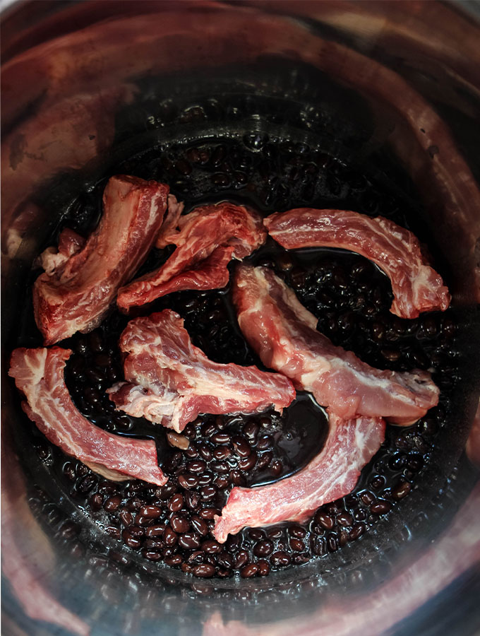 The ribs are tossed in to the pot with beans to simmer.