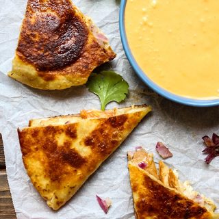 Easy and Quick Chicken and Cheese Quesadillas are cut into little triangles and plated with chipotle sauce.