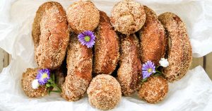 New England cider donuts are sugar coated and plated in a bowl.