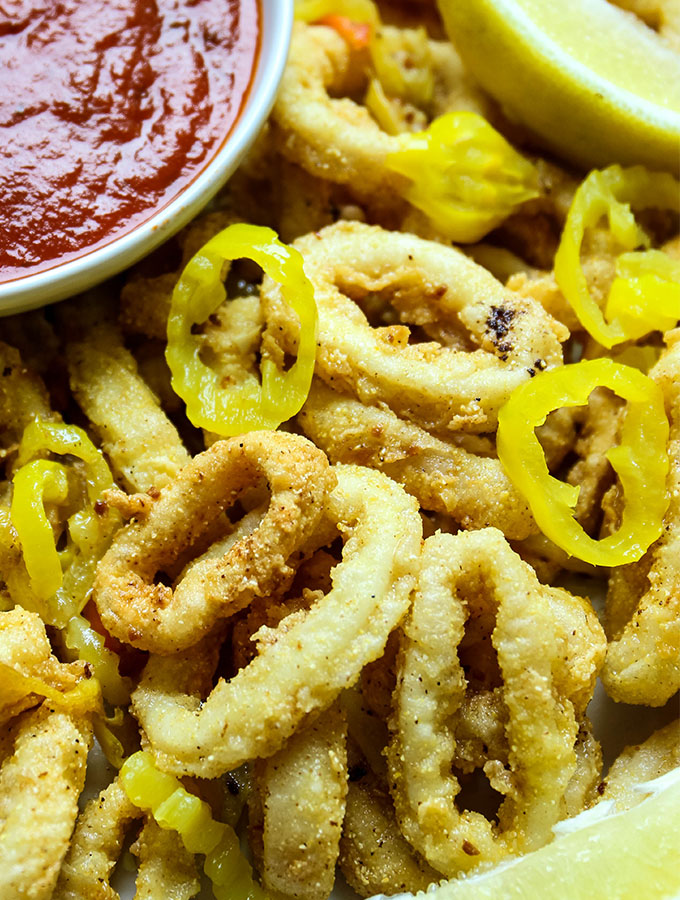 Rhode Island style calamari is plated with marinara sauce and more banana pepper rings.