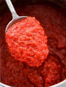 Easy Five Minute Marinara Sauce is scooped in a spoon to show texture.