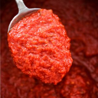 Easy Five Minute Marinara Sauce is scooped in a spoon to show texture.