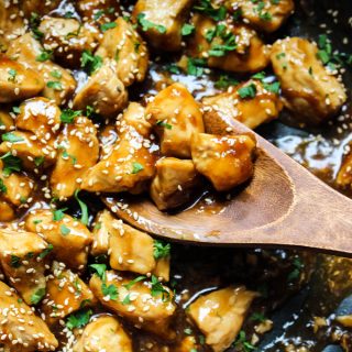 Teriyaki chicken is made quickly in a pan and topped with sesame seeds and fresh parsley.