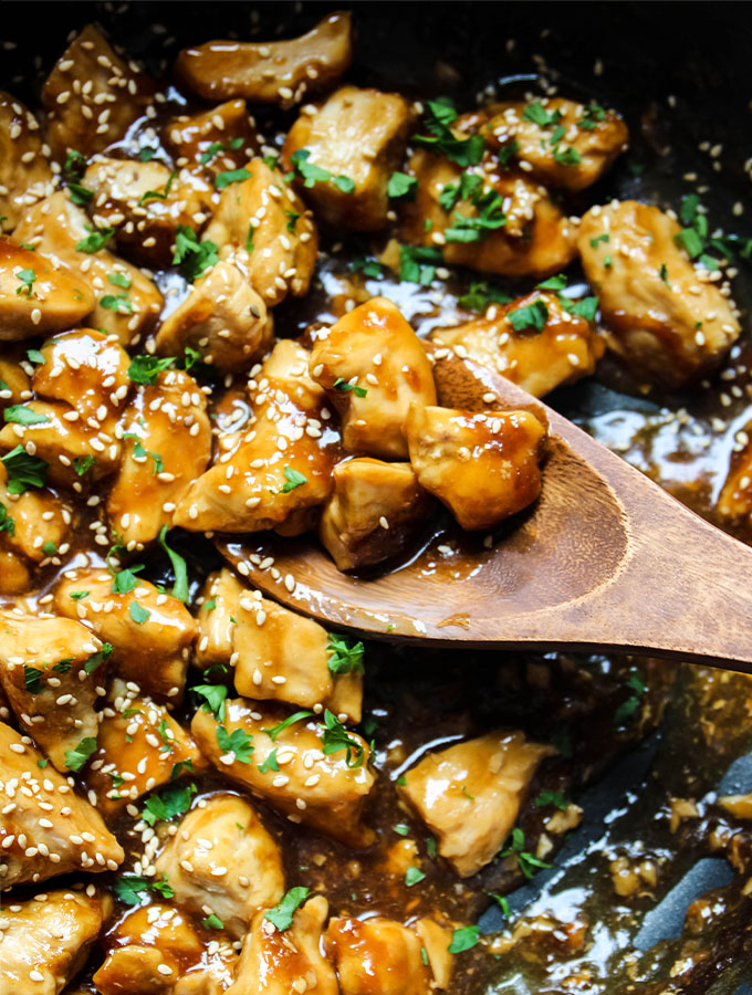 Teriyaki chicken is made quickly in a pan and topped with sesame seeds and fresh parsley.
