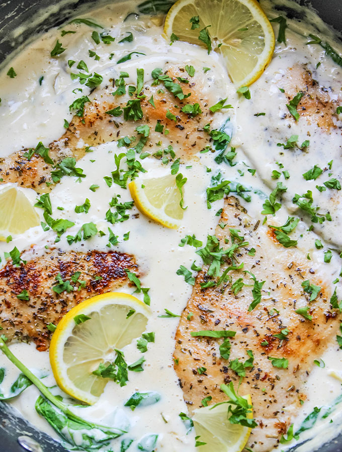 The chicken and creamy sauce is made in one pan then topped with fresh parsley and lemon wedges.